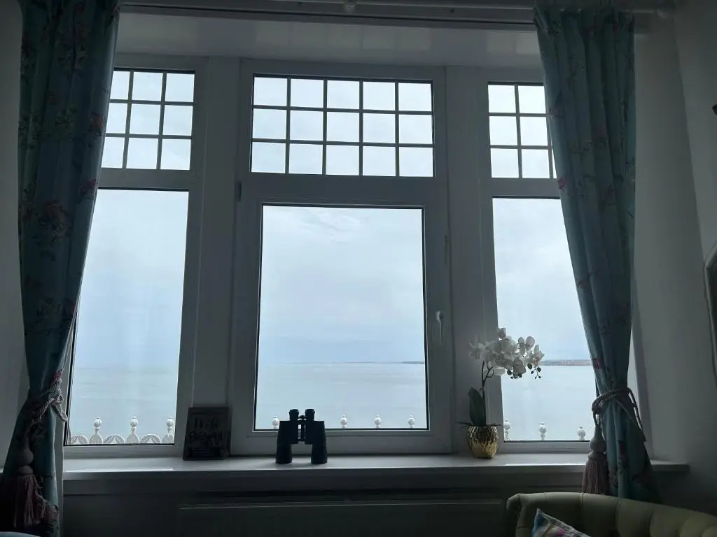 a window in a room with a view of the ocean at Tigh Na Mara Guest House Rosemarkie- breakfast optional in Rosemarkie