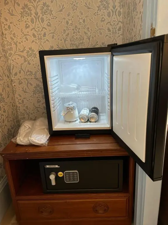 a microwave on top of a wooden table with a refrigerator at Tigh Na Mara Guest House Rosemarkie- breakfast optional in Rosemarkie