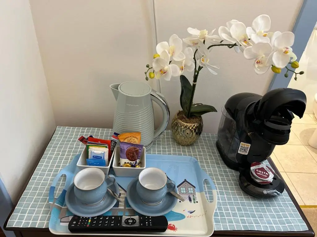 a table topped with a tray with cups and a coffee maker at Tigh Na Mara Guest House Rosemarkie- breakfast optional in Rosemarkie