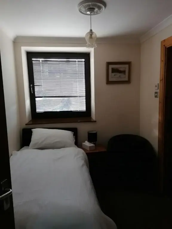 a bedroom with a white bed and a window at Granville Guest House in Dyce