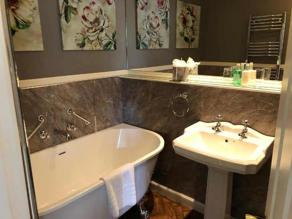 a bathroom with a bath tub and a sink at Coul House Hotel in Contin
