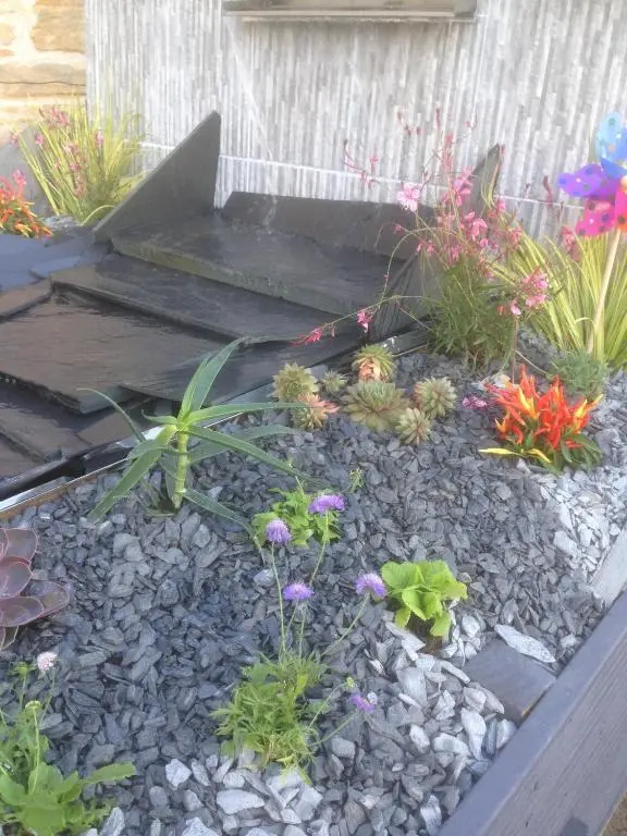 a garden with flowers and rocks in front of a building at Southbank Guesthouse in Elgin