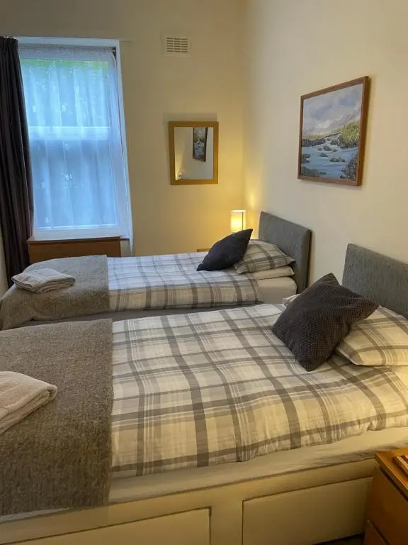 two beds sitting next to each other in a room at Reay Street Apartment in Inverness