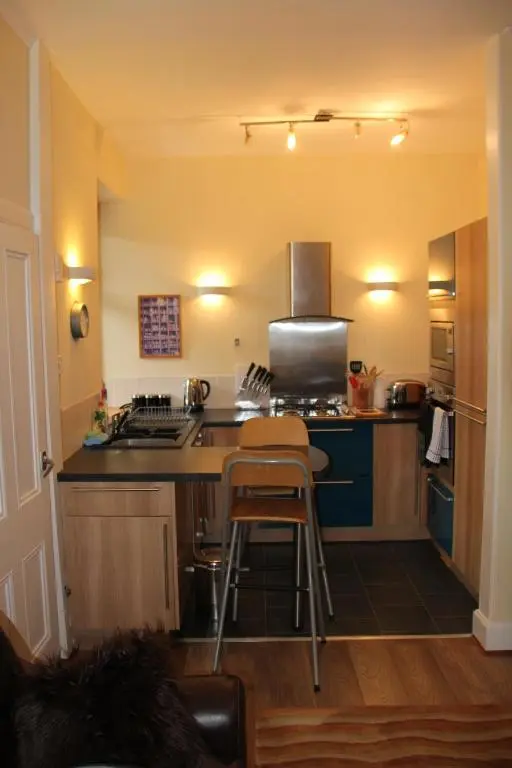 a kitchen with a stove and a counter top at Reay Street Apartment in Inverness