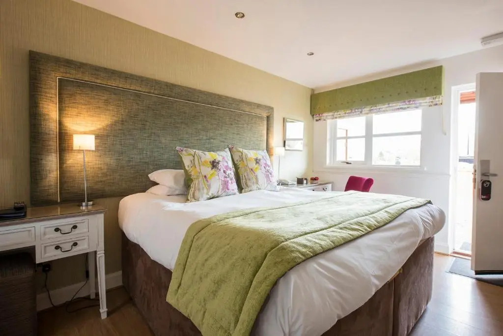 a bedroom with a large bed and a desk at The Lovat, Loch Ness in Fort Augustus