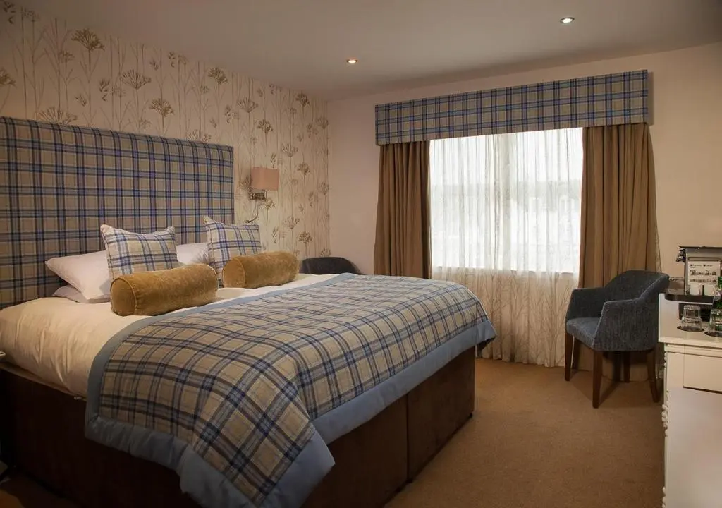 a bedroom with a bed and a window with curtains at The Lovat, Loch Ness in Fort Augustus
