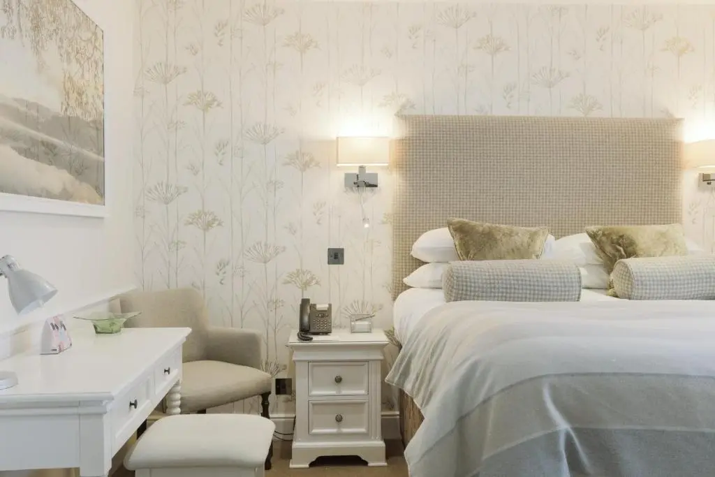 a bedroom with a bed and a desk and a chair at The Lovat, Loch Ness in Fort Augustus