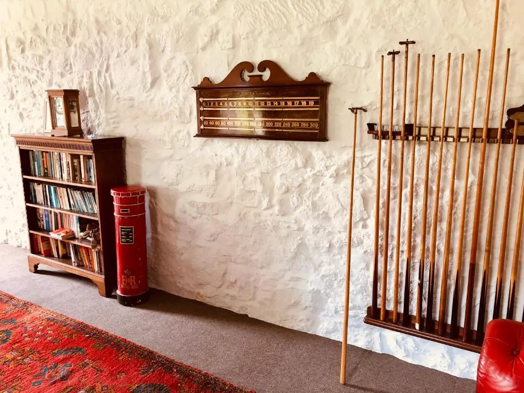 a corner of a room with a book shelf and a wall at Netherdale House & The Coach House in Turriff