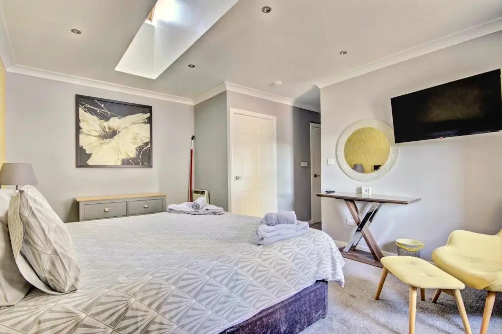 a bedroom with a large bed and a table and chairs at Thistle Apartment Golspie in Golspie