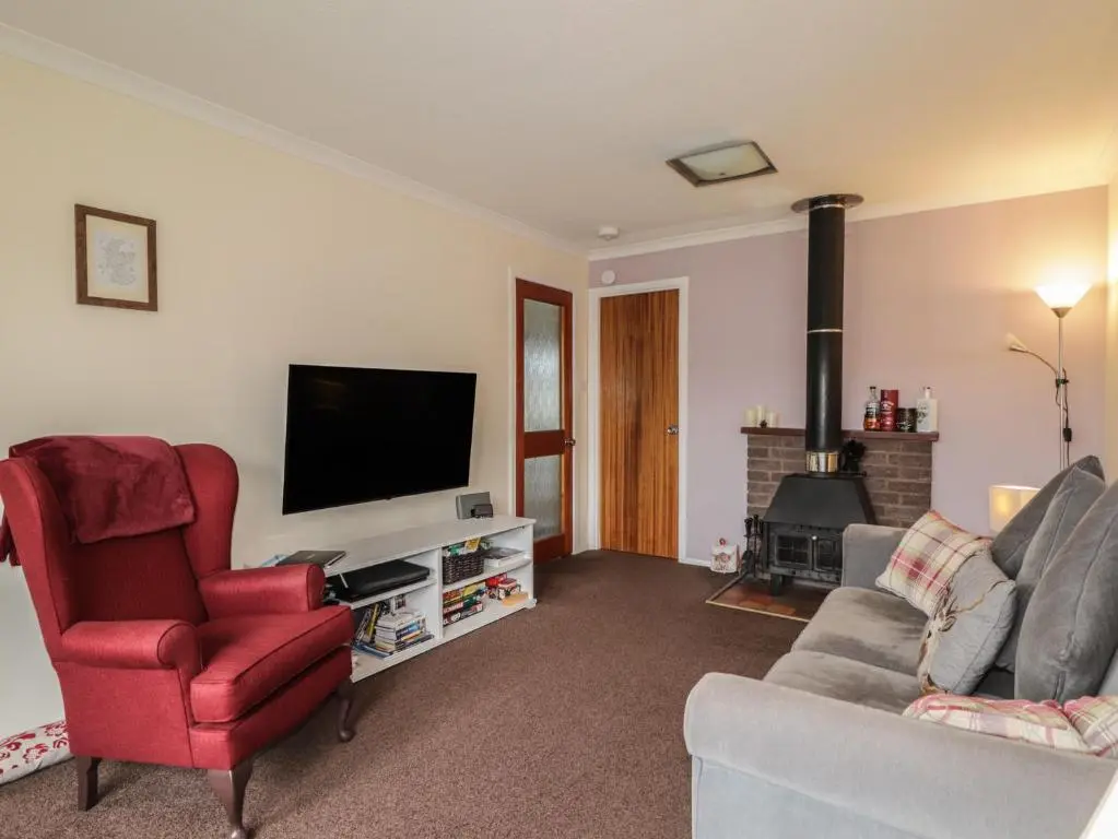 a living room with a couch and a tv at Steam Cottage in Aviemore