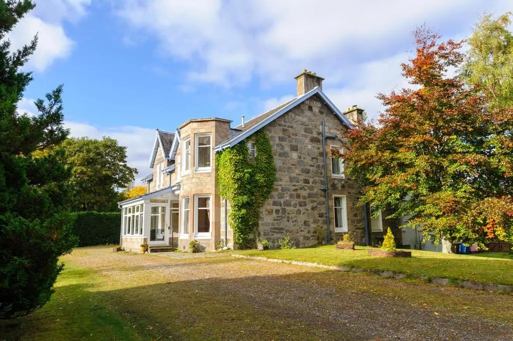 an old stone house with ivy growing on it at Alvey House in Newtonmore