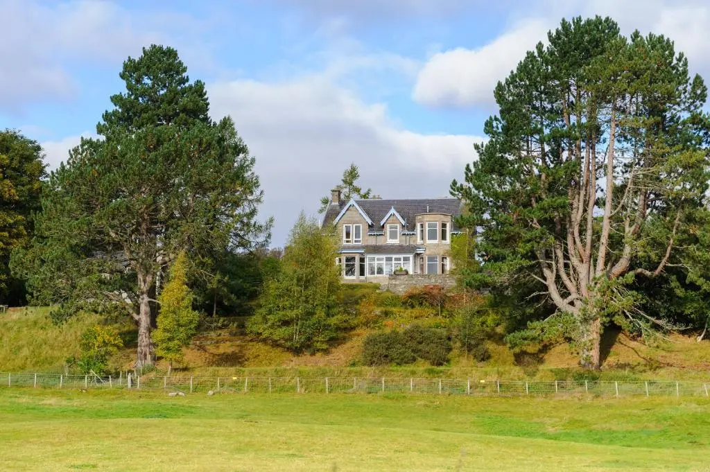 a house on top of a hill with trees at Alvey House in Newtonmore