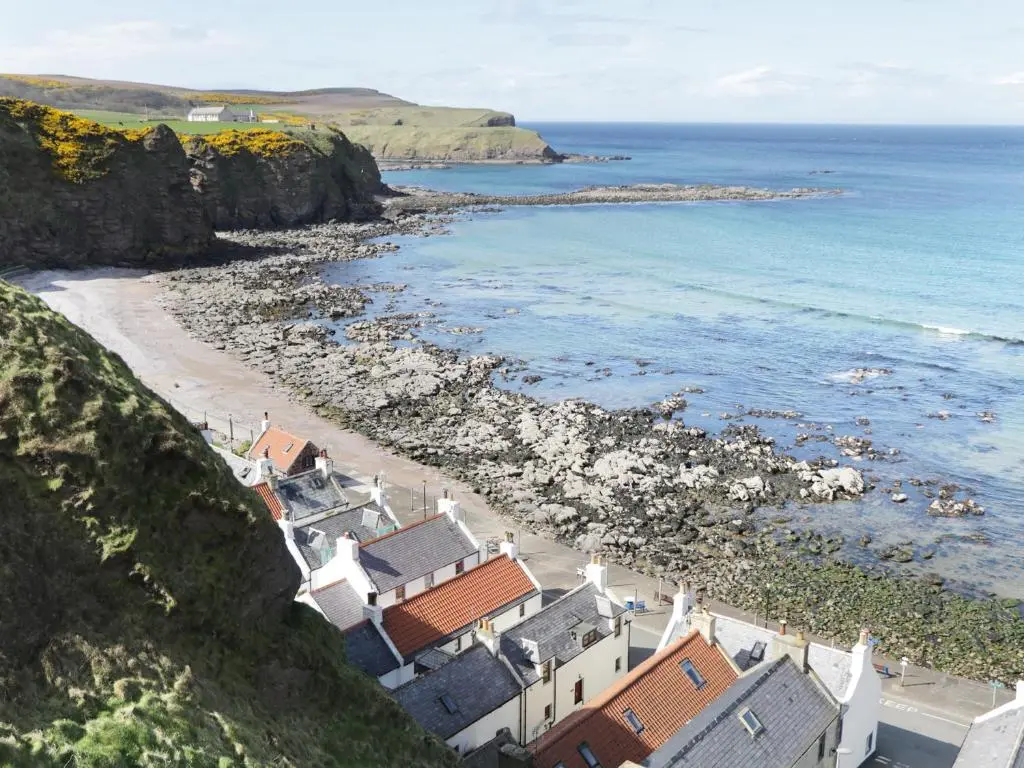a view of a beach with houses and the ocean at St Magnus Haven in Pennan