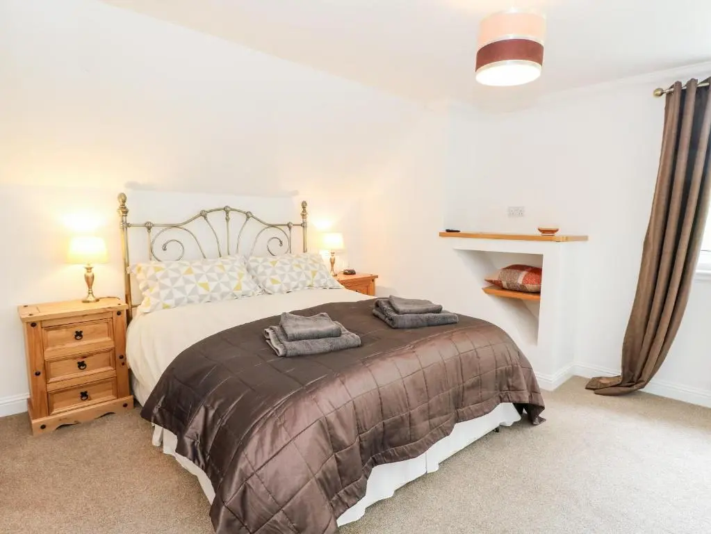 a bedroom with a bed with two towels on it at Tigh Na Drochit in Garve
