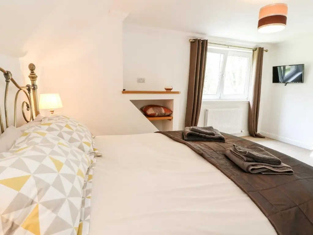 a bedroom with a bed and a window at Tigh Na Drochit in Garve