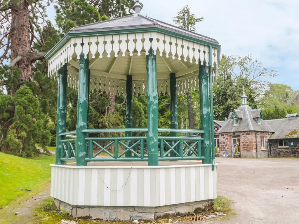 a green and white gazebo in a park at Otter Lodge in Strathpeffer