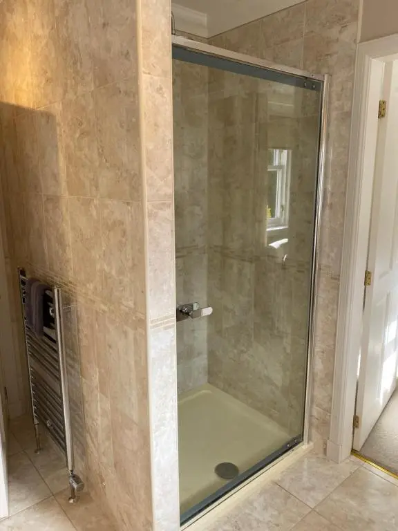 a shower with a glass door in a bathroom at Westwood Cottage in Aboyne