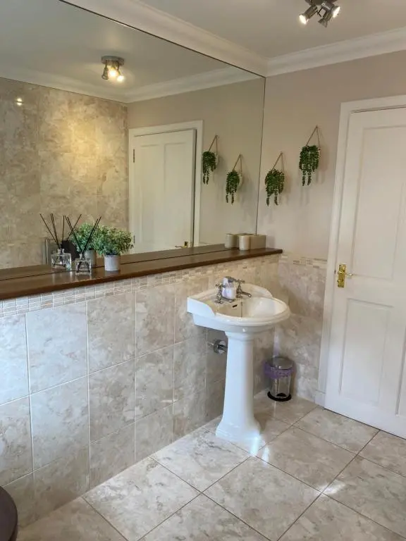 a bathroom with a sink and a mirror at Westwood Cottage in Aboyne
