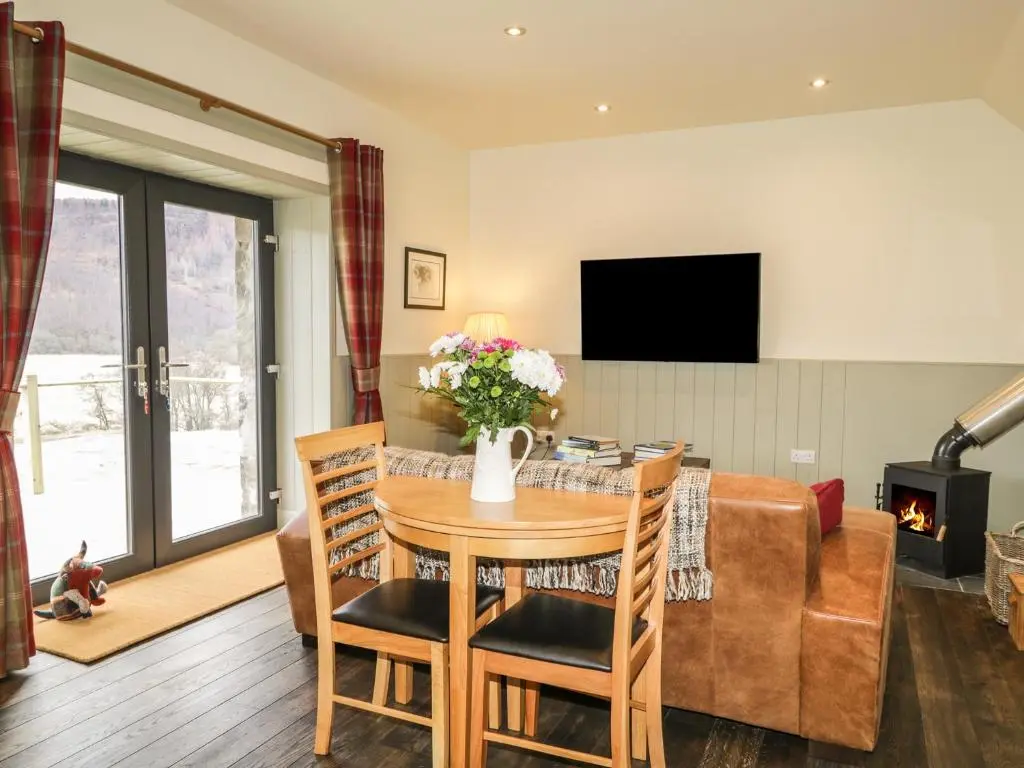 a living room with a table and a couch at East Craigdhu Cow Byre in Beauly