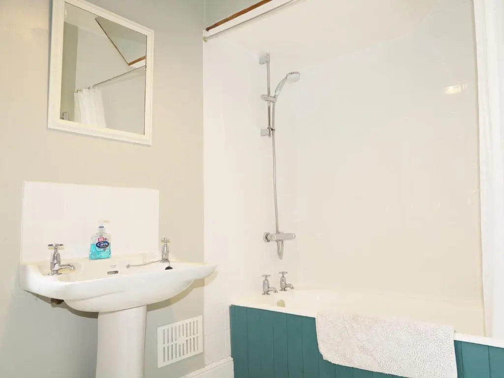 a bathroom with a sink and a mirror and a tub at Annfield in Aberlour