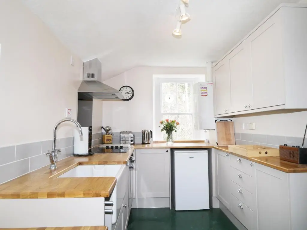 a kitchen with white cabinets and a sink at Annfield in Aberlour