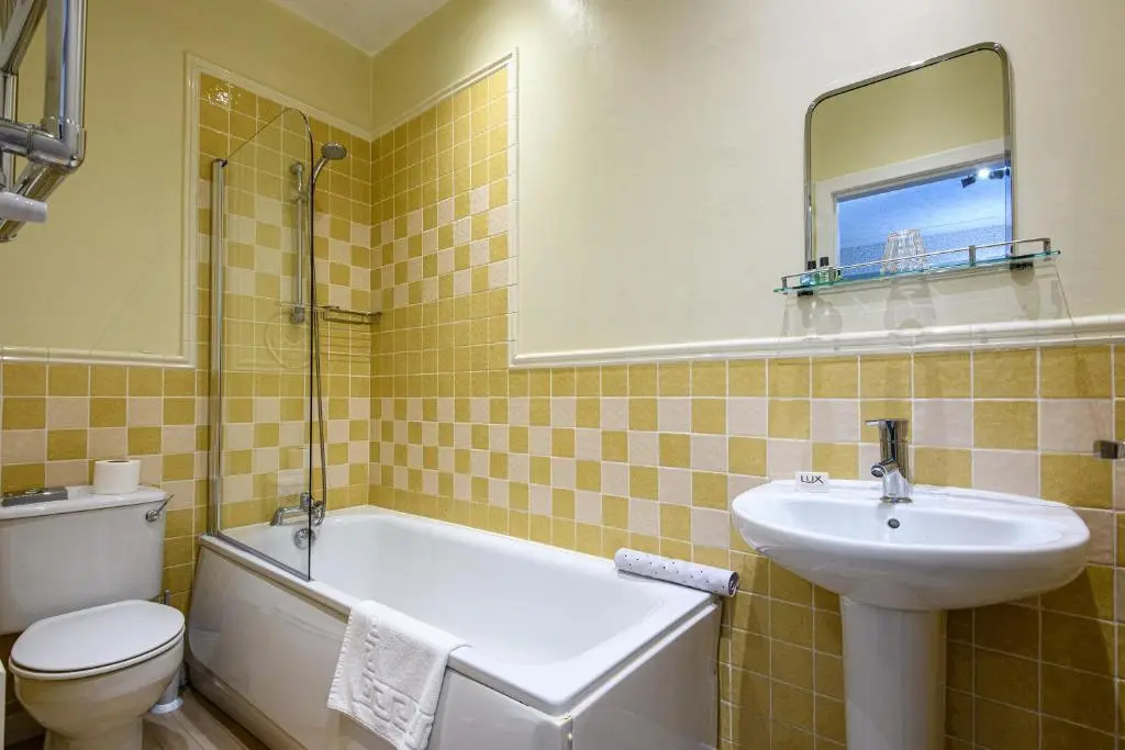 a bathroom with a sink and a tub and a toilet at The Portland Hotel in Lybster