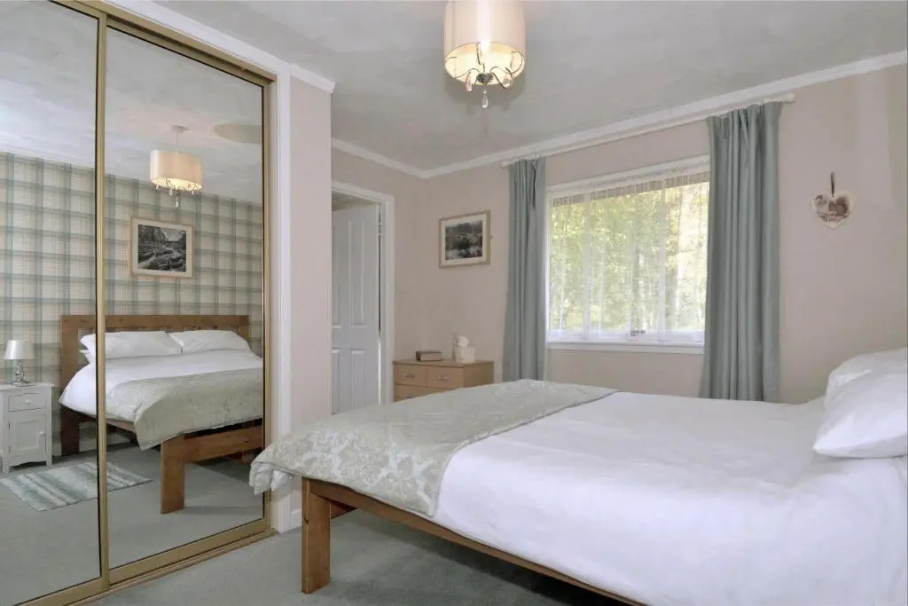 a bedroom with a bed and a mirror at The Bridge Suite in Invermoriston