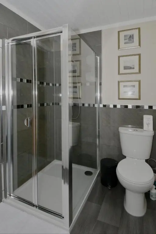a bathroom with a toilet and a glass shower at The Bridge Suite in Invermoriston