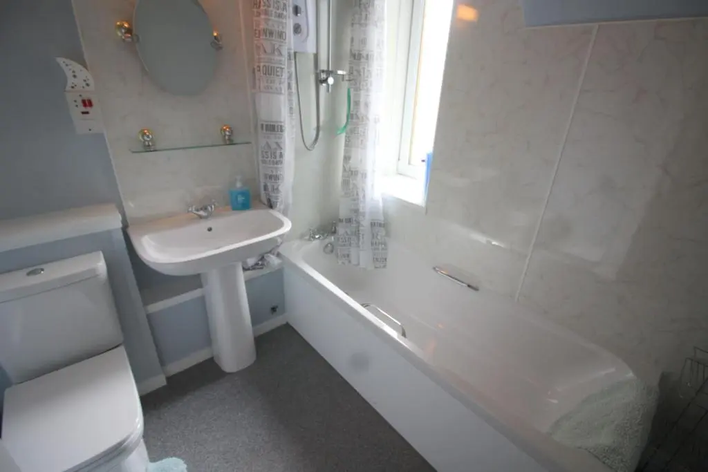 a bathroom with a sink and a tub and a toilet at Easdale House Apartments in Inverness