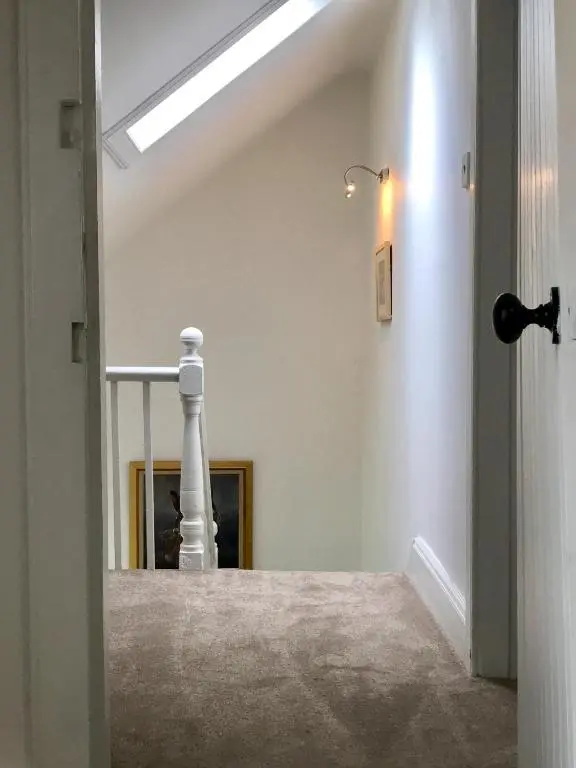 a hallway with a staircase with a skylight at Dandaleith Cottage No.2 in Craigellachie