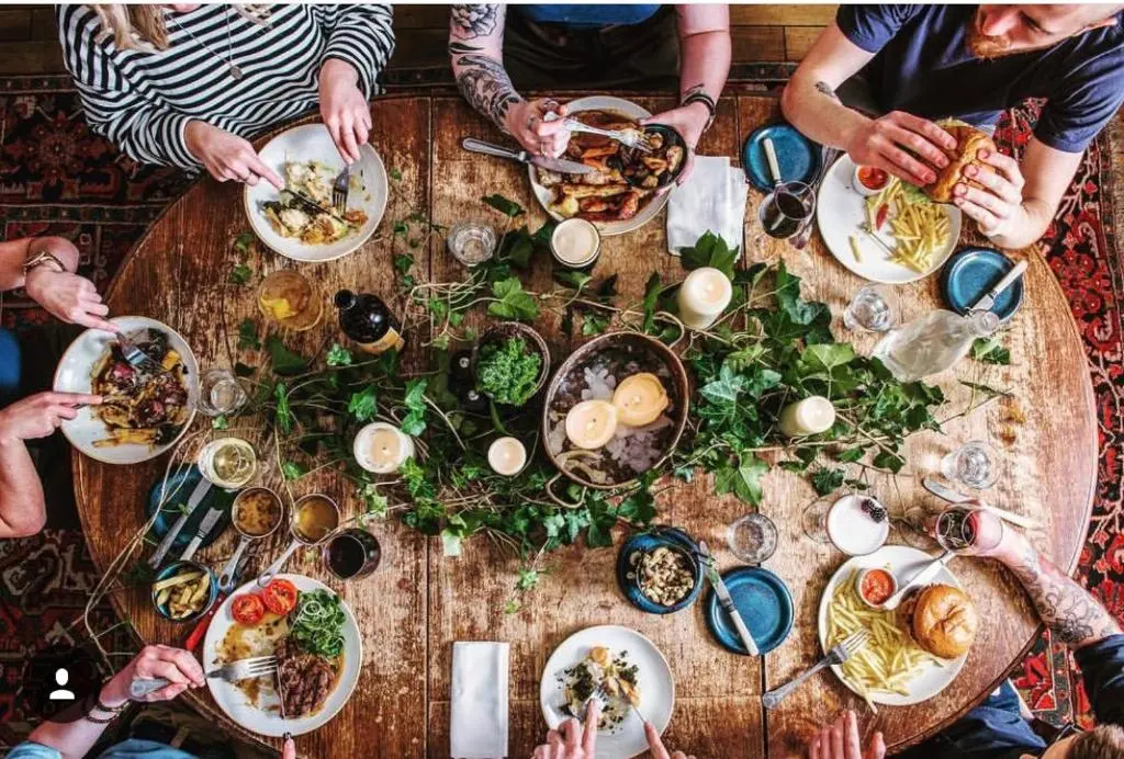 a group of people sitting around a table with food at Dandaleith Cottage No.2 in Craigellachie