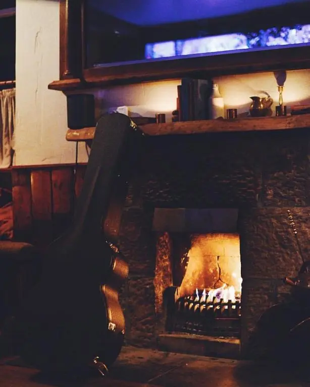 a brick fireplace with a fire in it at Dandaleith Cottage No.2 in Craigellachie