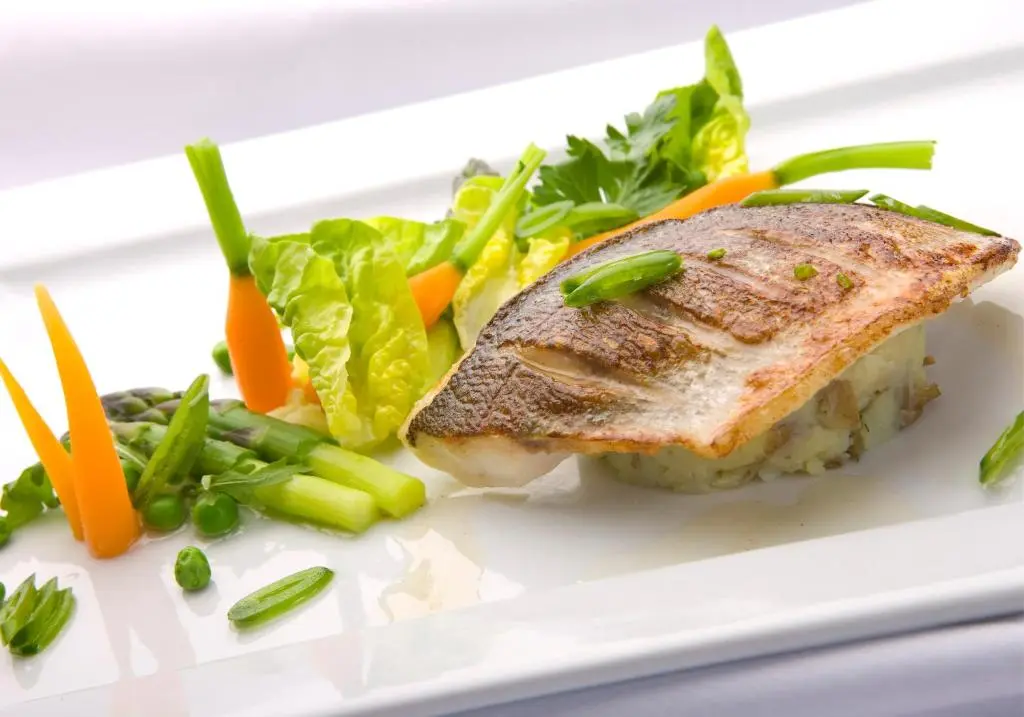 a plate of food with a piece of fish and vegetables at Kingsmills Hotel in Inverness