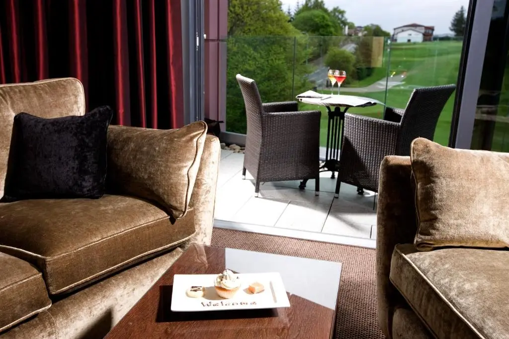 a living room with a couch and a table with chairs at Kingsmills Hotel in Inverness