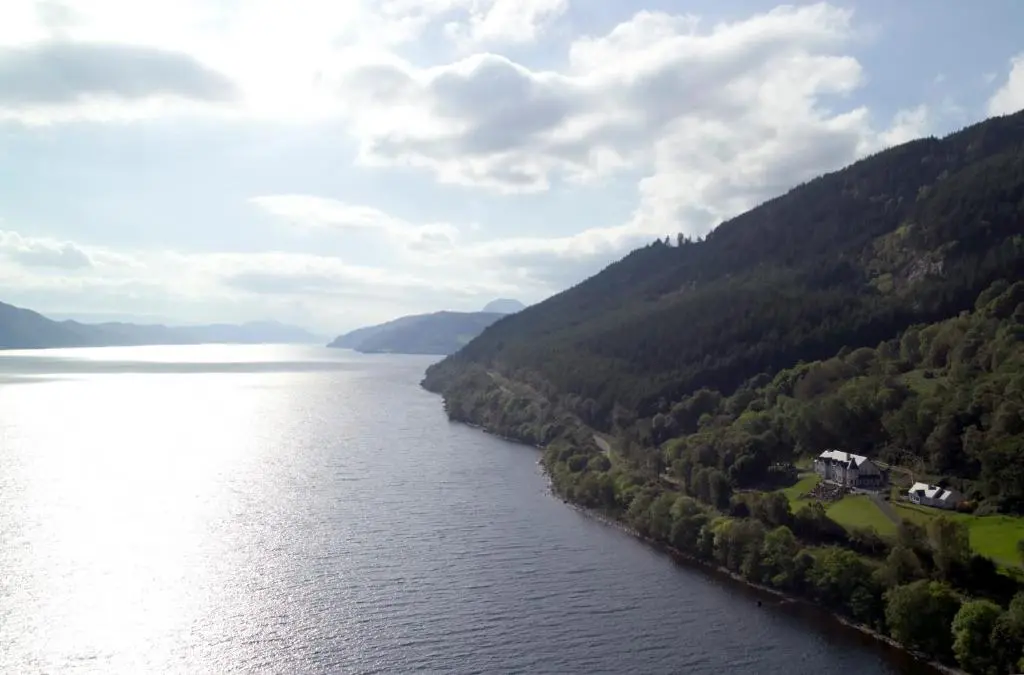 arial view of a river with trees and mountains at Loch Ness Lodge in Drumnadrochit