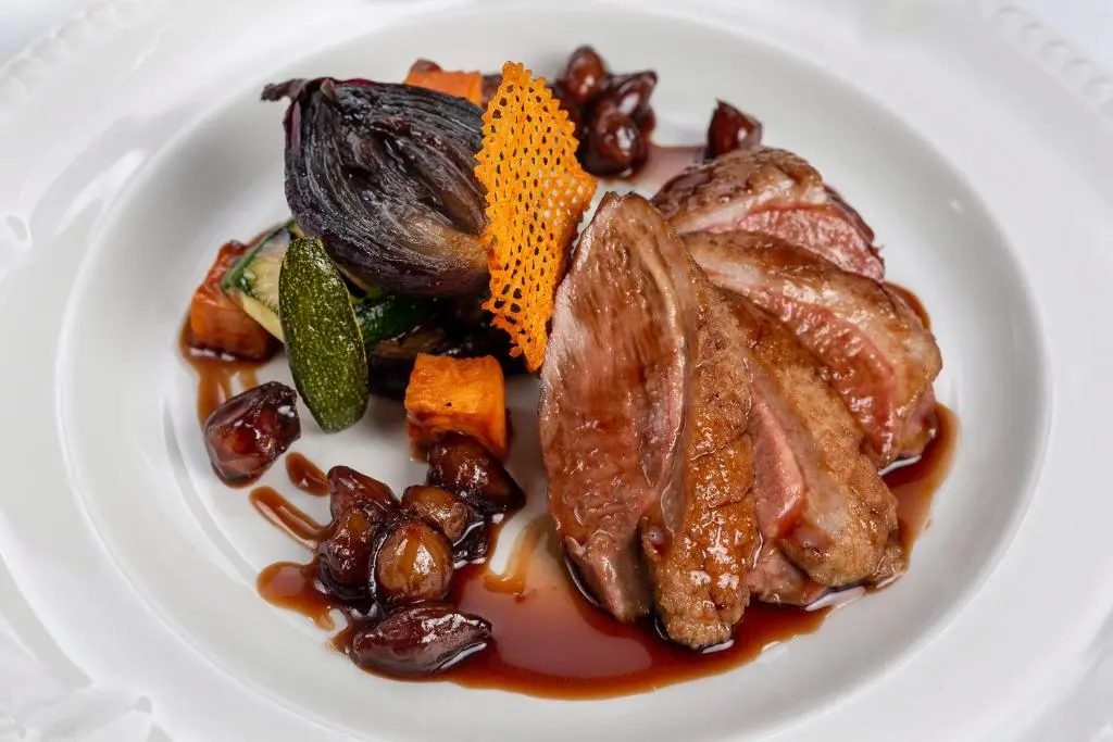 a white plate of food with meat and vegetables at Grant Arms Hotel in Grantown on Spey