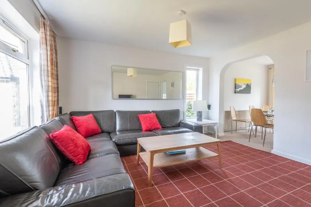 a living room with a leather couch and a table at White Corries in Aviemore