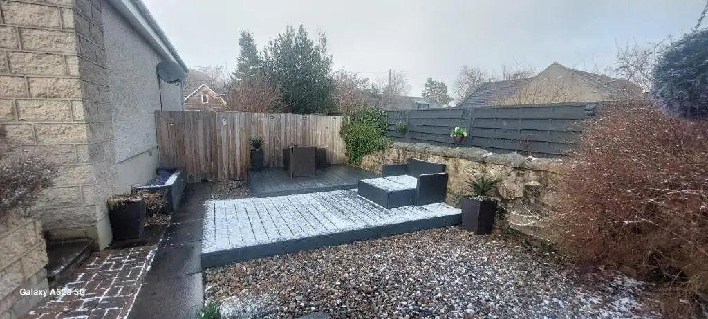 a backyard with a bench and a fence at Fairdene Cottage in Ballater