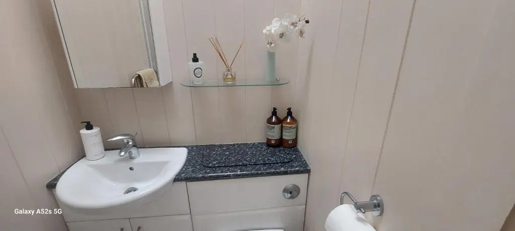 a small bathroom with a sink and a mirror at Fairdene Cottage in Ballater