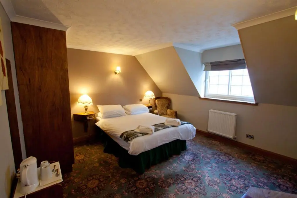 a hotel room with a bed and a window at Duke Of Gordon Hotel in Kingussie