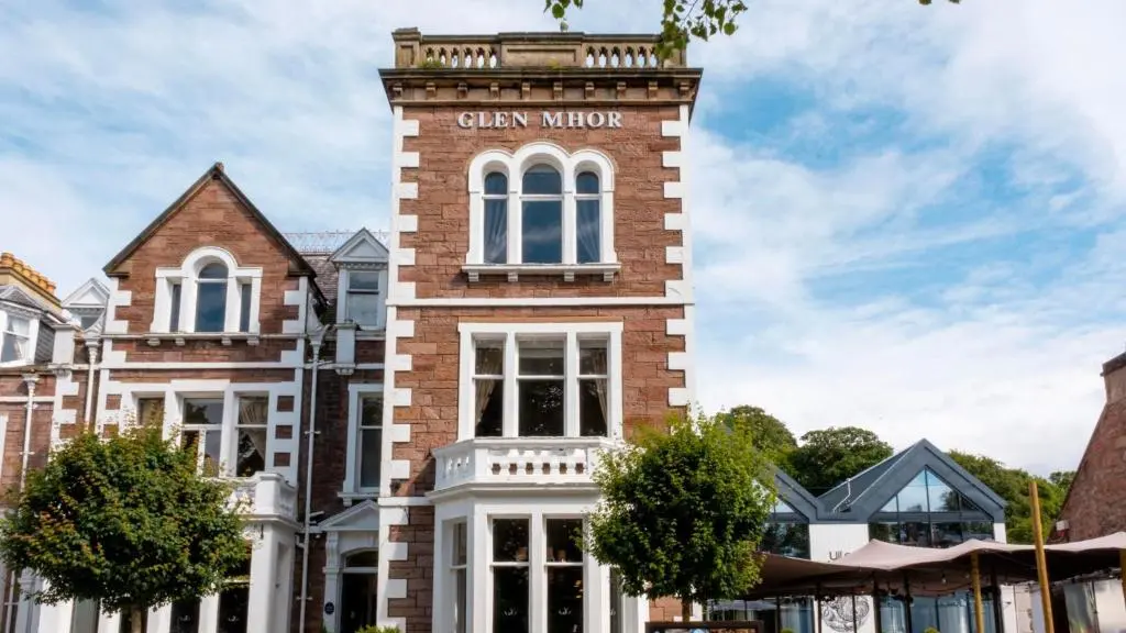 a tall brick building with a sign on it at Glen Mhor Hotel at Uile-bheist 'Brewstillery' in Inverness