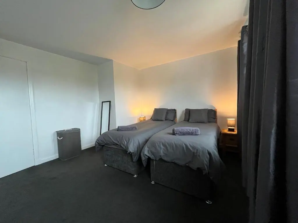 a bedroom with a large bed with two pillows at Inverness House in Inverness