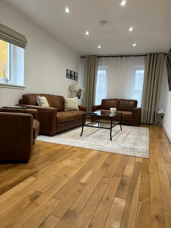 a living room with two couches and a table at Gateway Apartment in Inverness
