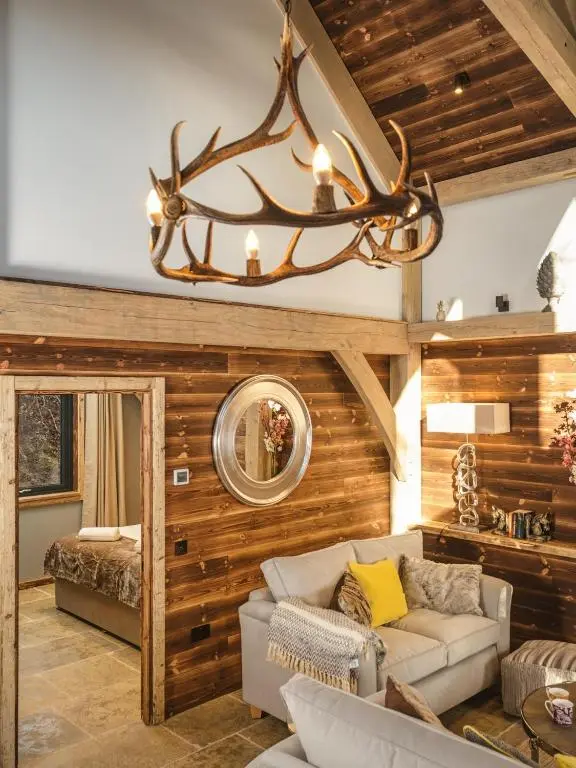 a living room with a couch and a chandelier at Cairngorm Lodge in Aviemore