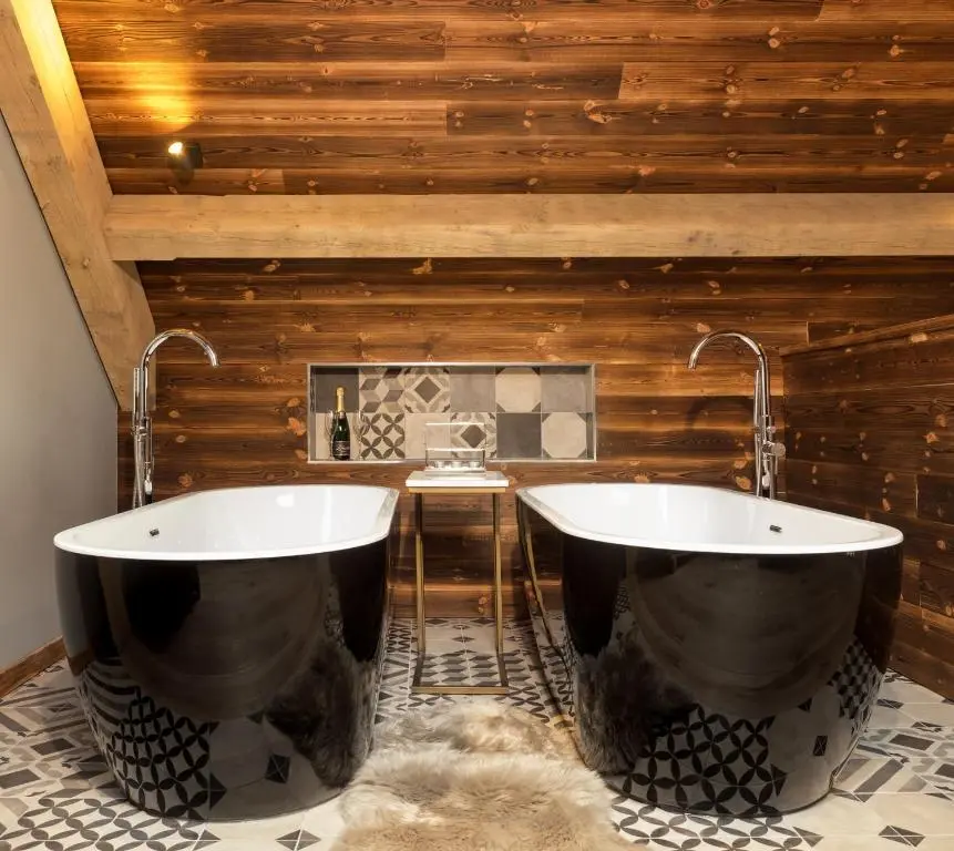 a bathroom with two tubs on a tiled floor at Macdui Lodge in Aviemore