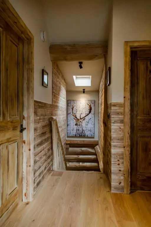 a hallway with stairs and a painting on the wall at Cedar Lodge in Aviemore