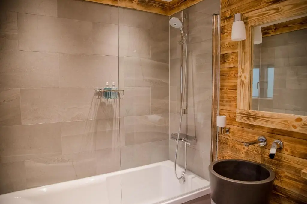 a bathroom with a shower and a bath tub at Cedar Lodge in Aviemore