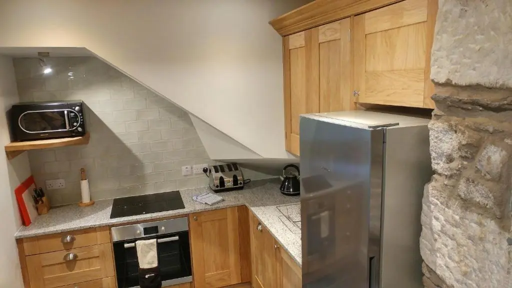 a kitchen with a stainless steel refrigerator and wooden cabinets at Shieling in Aviemore