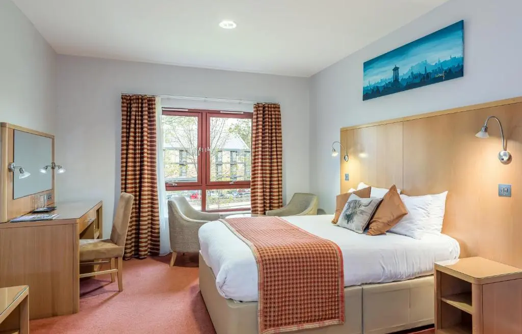 a hotel room with a bed and a desk at High Range Lodge Hotel in Aviemore
