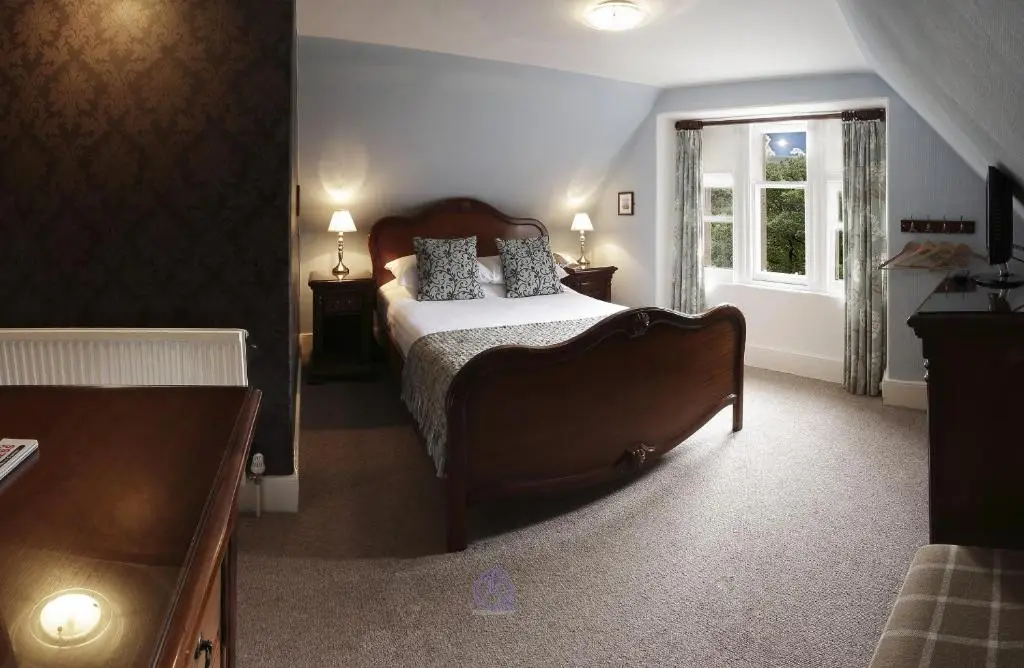 a bedroom with a large bed and a window at Invergarry Hotel in Invergarry